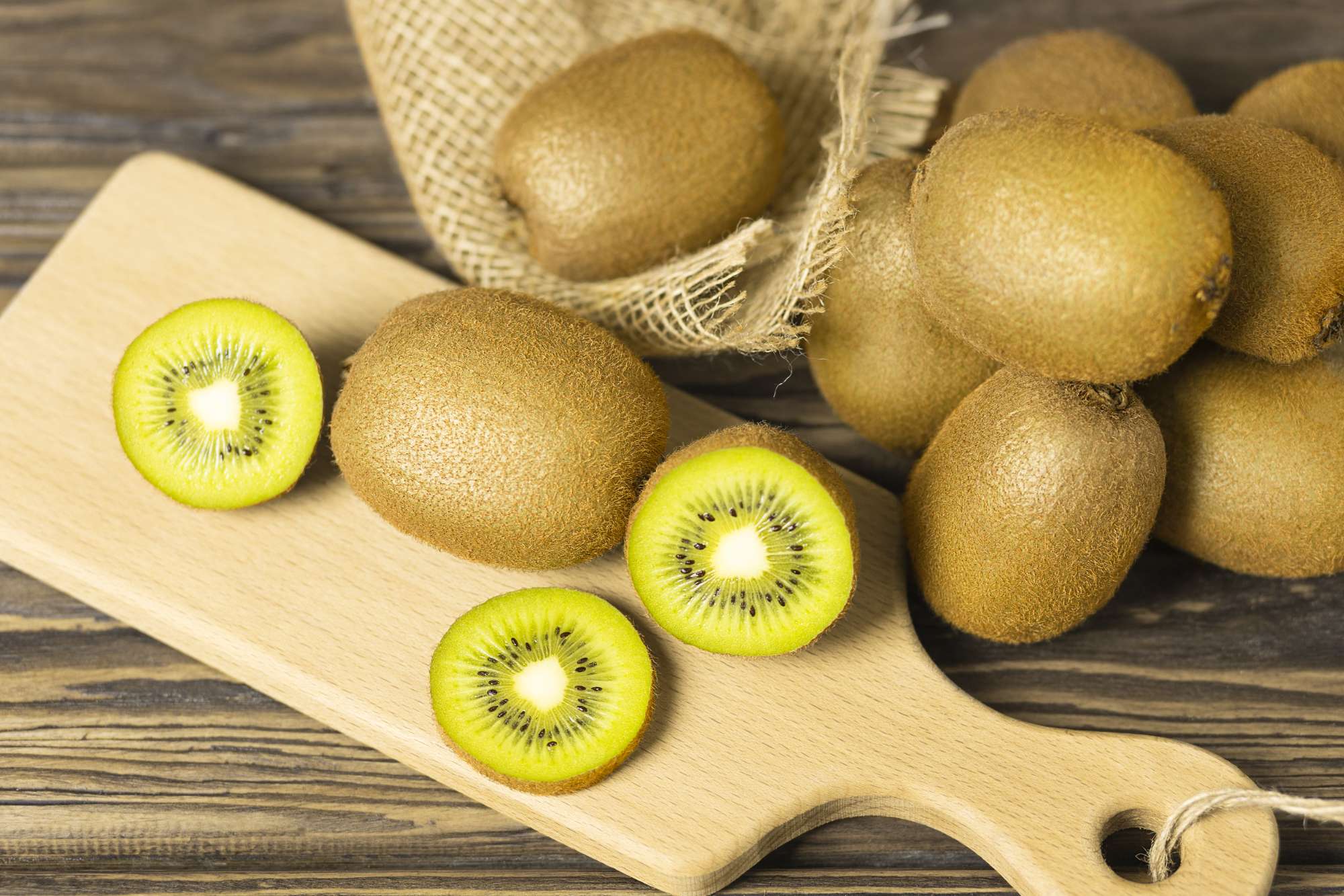 lot-whole-half-exotic-brown-kiwi-bamboo-chopping-board-wooden-table-selective-focus.jpg