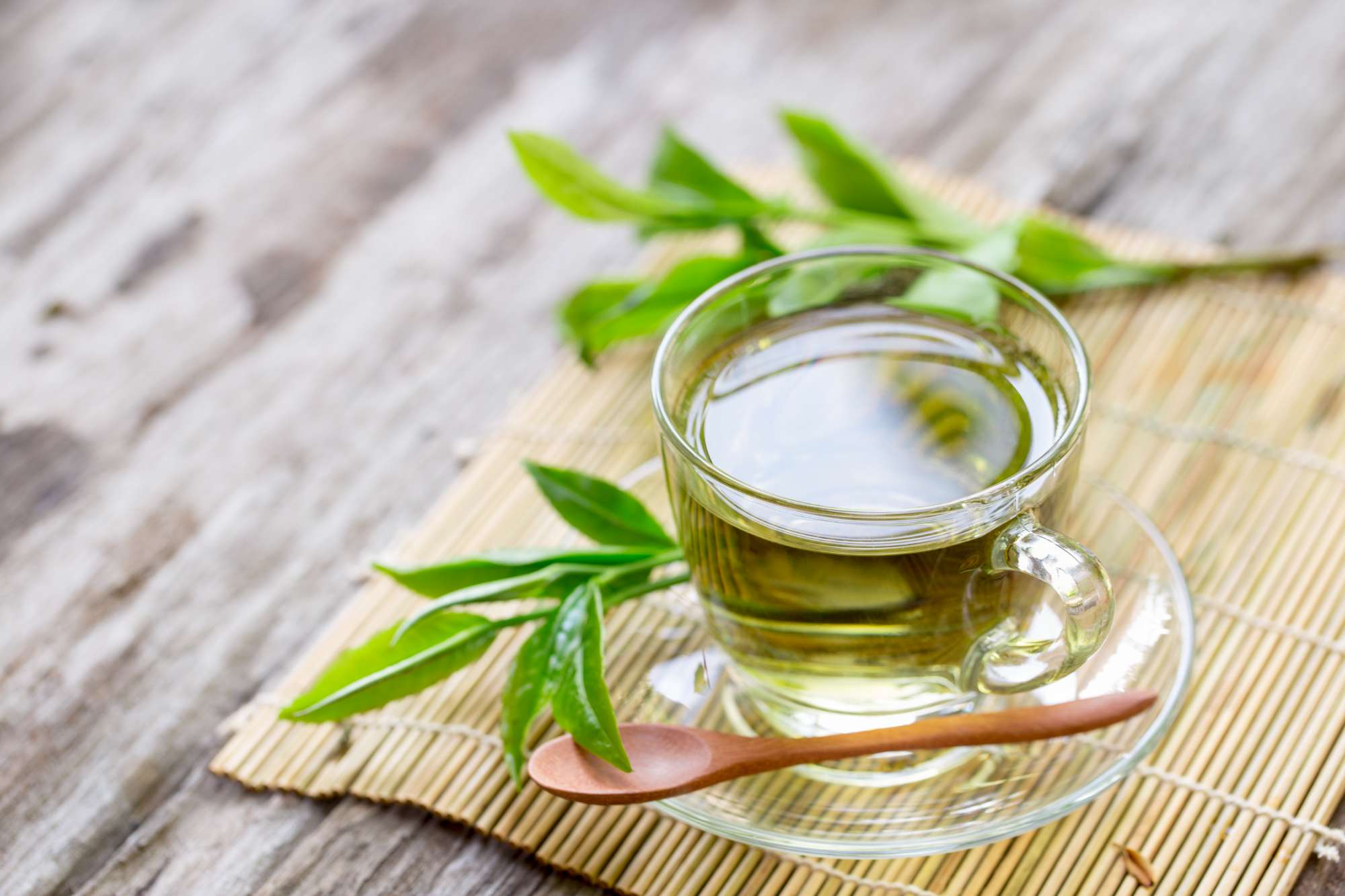 fresh-green-tea-with-tea-leaves-water-wood-table.jpg